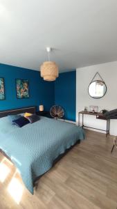 ein Schlafzimmer mit blauen Wänden und einem großen Bett in der Unterkunft Malo les bains Appt à 7 minutes de la plage in Dunkerque