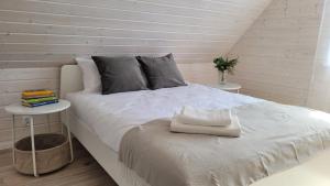 a bedroom with a white bed with a side table at Lis i Mewa Domy Apartamentowe in Wicie