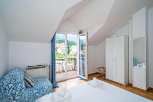 sypialnia z kanapą, łóżkiem i oknem w obiekcie Francesca Guesthouse w mieście Mlini