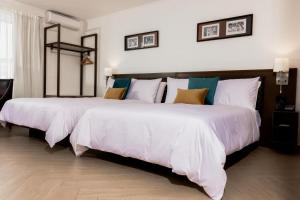 a bedroom with two beds with white sheets at Capricorn Hotel Suva in Suva