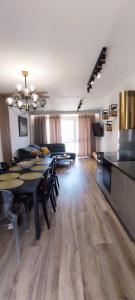 ein großes Wohnzimmer mit einem Tisch und einer Küche in der Unterkunft Apartament Olchowa Prestige 3 in Ustroń
