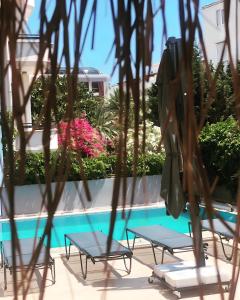- deux tables et des chaises à côté de la piscine dans l'établissement BERRY BELLA HOTEL, à Marmaris