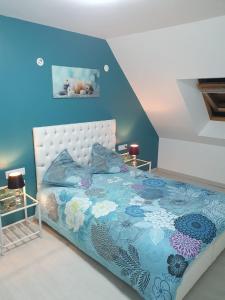 a bedroom with a bed with a blue wall at BELLE MAISON A Ménars in Menars