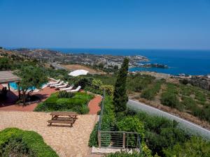 eine Terrasse mit einem Tisch, Stühlen und Meerblick in der Unterkunft Villa Hara in Agia Pelagia