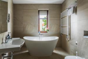 łazienka z wanną, 2 umywalkami i oknem w obiekcie No.23 Premium Aparthotel w Krakowie