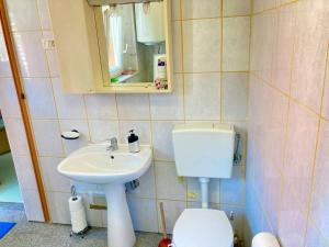 y baño con lavabo, aseo y espejo. en Relax house near Croatia en Piran