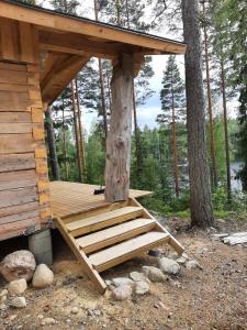 a wooden cabin with a staircase next to a tree at Villa Ulappa in Savonlinna +6 photos