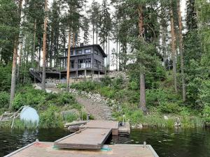 ein Haus an der Seite eines Flusses mit einem Dock in der Unterkunft Villa Ulappa in Savonlinna