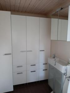 una cocina blanca con fregadero y armarios blancos en Villa Ulappa, en Savonlinna