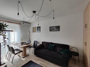 a living room with a black couch and a table at Kinizsi Apartman in Miskolc