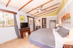 um quarto com uma cama e uma televisão de ecrã plano em Xalli Beach Hotel em Altagracia