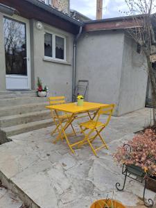 a yellow table and chairs on a patio at Gîte 3 "le Canal de Baza" aux Magnolias in Aubenas