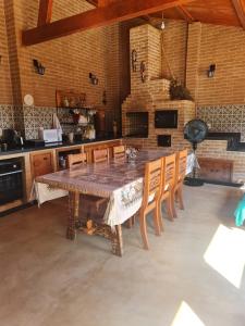 a large kitchen with a wooden table and chairs at Hospedagem Casa do Chapéu Caparaó in PatrimÃ´nio da Penha
