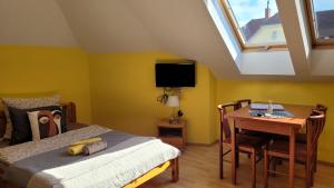 ein Schlafzimmer mit Bett, Schreibtisch und Fenster in der Unterkunft Villa Zlata Praha in Hévíz