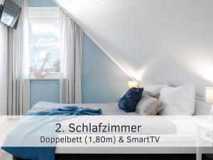 une chambre avec un lit avec un mur bleu dans l'établissement Lotsenbude Fehmarn, perfekt für Familien & Paare, Nähe Hafen Burgstaaken, à Burg