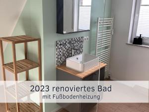 une salle de bain avec un lavabo et un miroir dans l'établissement Lotsenbude Fehmarn, perfekt für Familien & Paare, Nähe Hafen Burgstaaken, à Burg