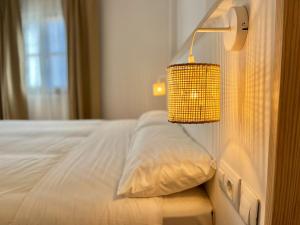 ein Schlafzimmer mit einem Bett mit einer Lampe an der Wand in der Unterkunft Casa La Aguanosa con piscina y vistas al mar in Frigiliana + 9 Fotos