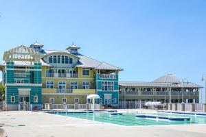 a large building with a pool in front of it at Sunset Island Luxury 3BR Unit – Free Linen Package in Ocean City