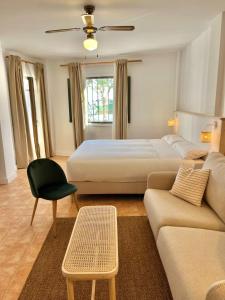 ein Hotelzimmer mit einem Bett und einer Couch in der Unterkunft Casa La Aguanosa con piscina y vistas al mar in Frigiliana