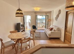 uma sala de estar com um sofá e uma mesa em Casa La Aguanosa con piscina y vistas al mar em Frigiliana