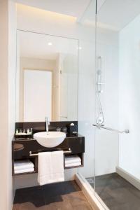 a bathroom with a sink and a glass shower at Four Points by Sheraton Jakarta Thamrin in Jakarta