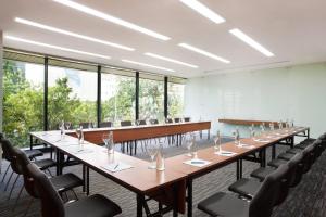 a row of tables and chairs in a room with windows at Four Points by Sheraton Jakarta Thamrin in Jakarta