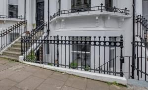 ein schwarzer Zaun vor einem Haus mit Treppen in der Unterkunft Central Brighton flat, 3 bedrooms, sleeps 6, close to shops and beach in Brighton & Hove