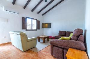 sala de estar con sofá y silla en Casa Torres - Traditional Village Experience, en Cánovas