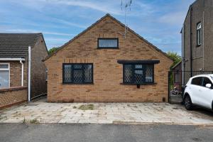 a brick house with a car parked in front of it at 7 Guests - 4 Bedroom - Free Wi-Fi - Kettering in Kettering
