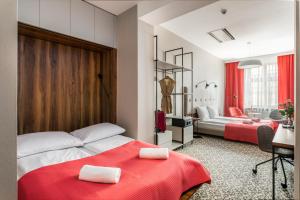 a bedroom with two beds with a red blanket at No.23 Premium Aparthotel in Krakow