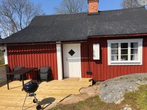 - un bâtiment rouge avec un grill en face dans l'établissement Malghults Gård, à Kristdala