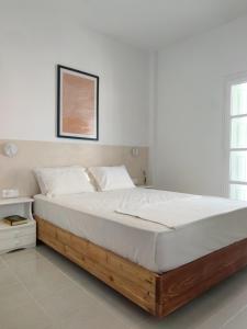 a bedroom with a large bed with white sheets at Lithi Stylish Apartments- Eco Luxury Suite in Tripití