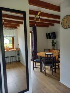 a dining room and kitchen with a table and a clock at Zagroda wypoczynkowa- Domki nad rzeką in Smerekowiec