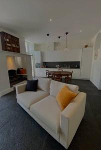 a living room with a white couch and a kitchen at Laglio Charlie's House Lake View in Laglio