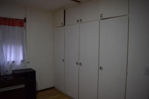 Pokój z białymi szafkami i białą ścianą w obiekcie Silvia's house w mieście Ushuaia