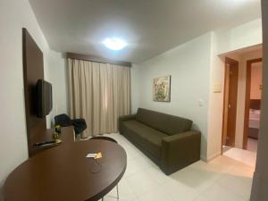 カルダス・ノバスにあるPrive Boulevard Suite Hotelのソファとテーブルのあるリビングルーム