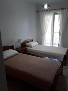 una camera con due letti e una finestra di Theros Apartment a Spartokhórion