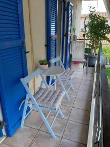 a patio with two chairs and a table and a blue door at Theros Apartment in Spartokhórion