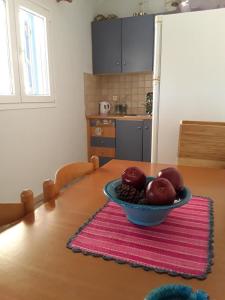 uma mesa com uma tigela de maçãs em cima em Theros Apartment em Spartokhórion