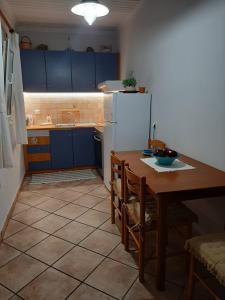 a kitchen with a table and a white refrigerator at Theros Apartment in Spartokhórion