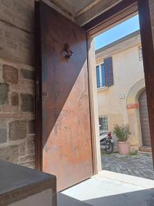 uma porta aberta com um urso de peluche em cima em CasAlice Room&Breakfast in centro storico em Santarcangelo di Romagna