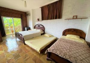 a bedroom with two beds and a brick wall at Muyuyo Lodge in Ayangue +56 photos