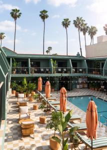 a view of the pool at the resort with orange umbrellas at Palihotel Hollywood near Universal Studios in Los Angeles