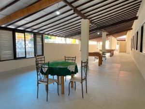a dining room with a green table and chairs at Hotel Boavista in Miguel Pereira