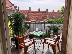 a patio with two chairs and a table on a balcony at Bij Frits in Zandvoort