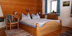 a bedroom with a wooden bed and a chair at Ferienwohnung Lugererlehen in Schönau am Königssee +8 photos