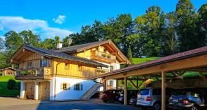 a large wooden house with cars parked in a parking lot at Ferienwohnung Lugererlehen in Schönau am Königssee