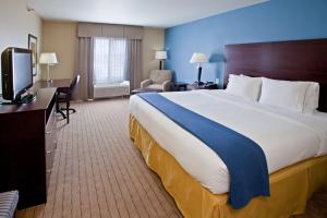 a hotel room with a large bed and a television at Holiday Inn Express Hotel & Suites Shelbyville, an IHG Hotel in Shelbyville