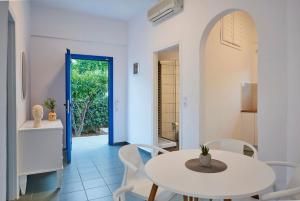 een witte eetkamer met een tafel en stoelen bij Veneto Sea View Apartments in Stalida
