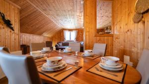 a dining room table with cups and saucers on it at Apartman DAVID sa unutarnjim bazenom in Brod Moravice